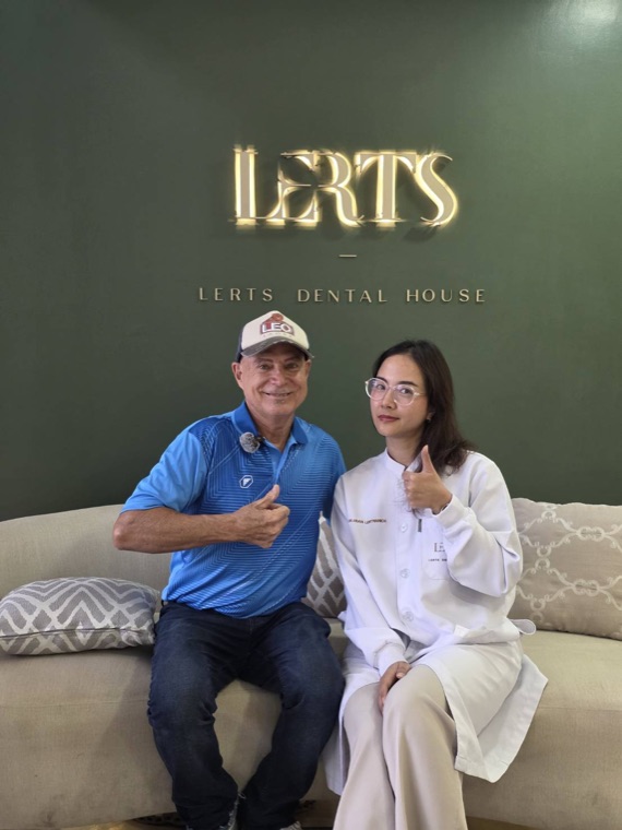 Patient and clinician giving a thumbs up at the LERTS Dental House logo wall, Chiang Mai