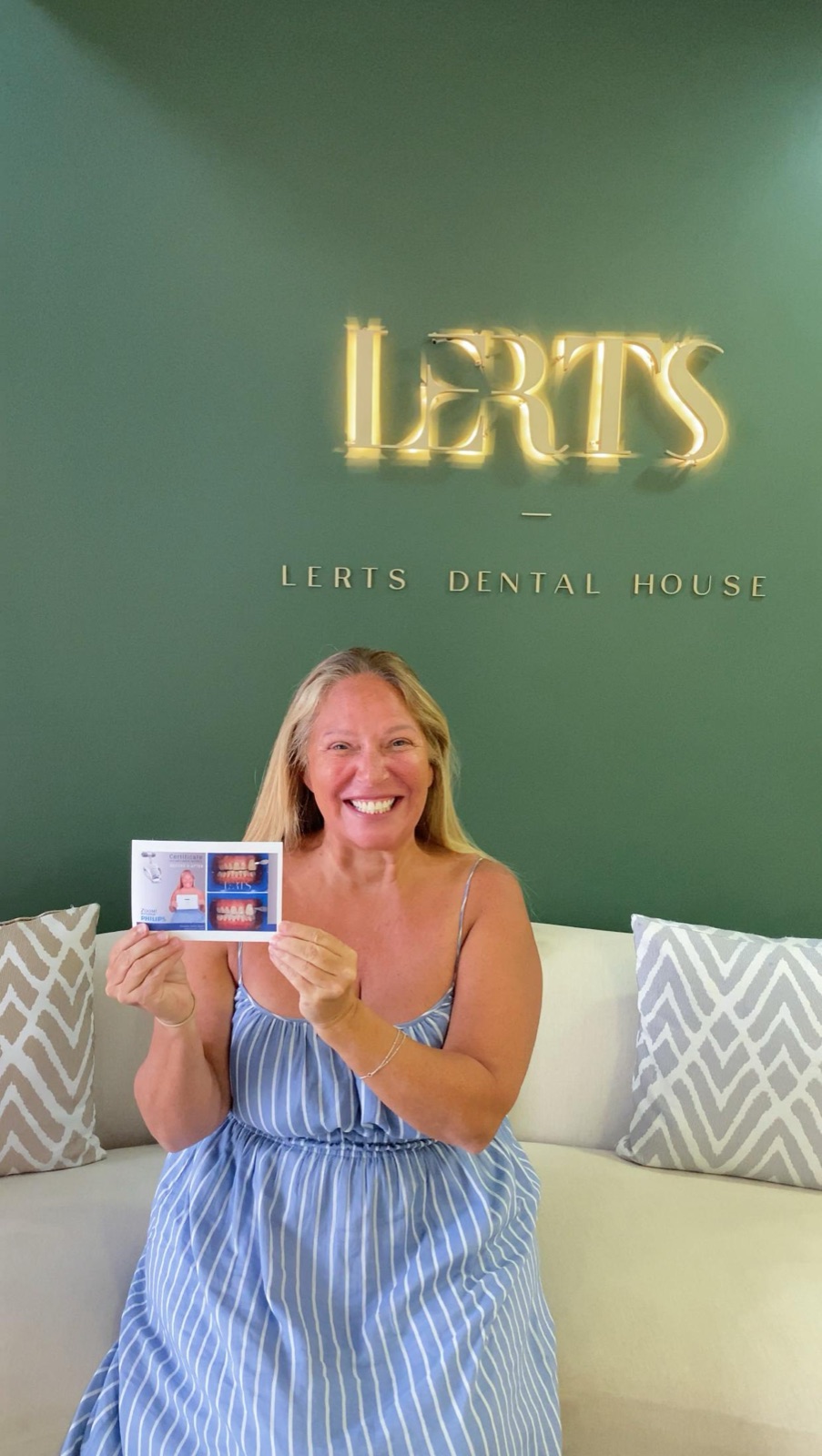 Ms. Shareen at Dental Excellence by LERTs holding her professional teeth whitening result card